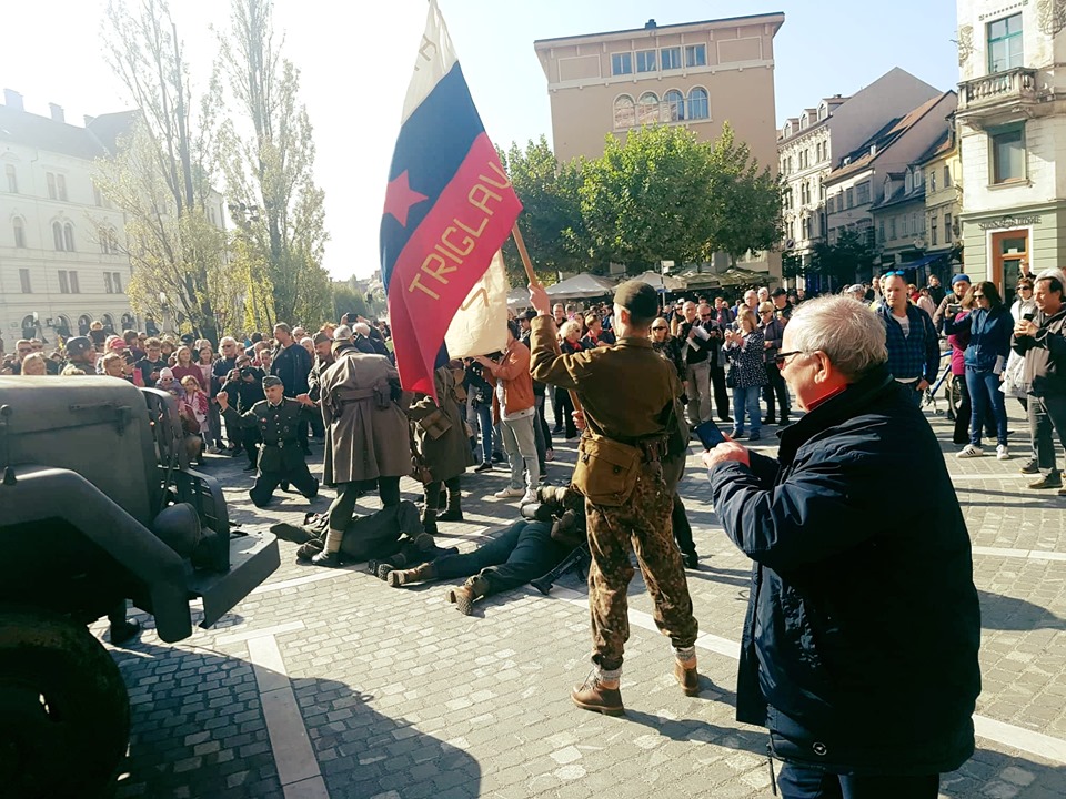 (VIDEO) Nemci včeraj “zasedli” Ljubljano, ki pa je bila v nekaj minutah spet “osvobojena” – Na promociji filma “Preboj” tudi transparent “Rešimo se Janše”