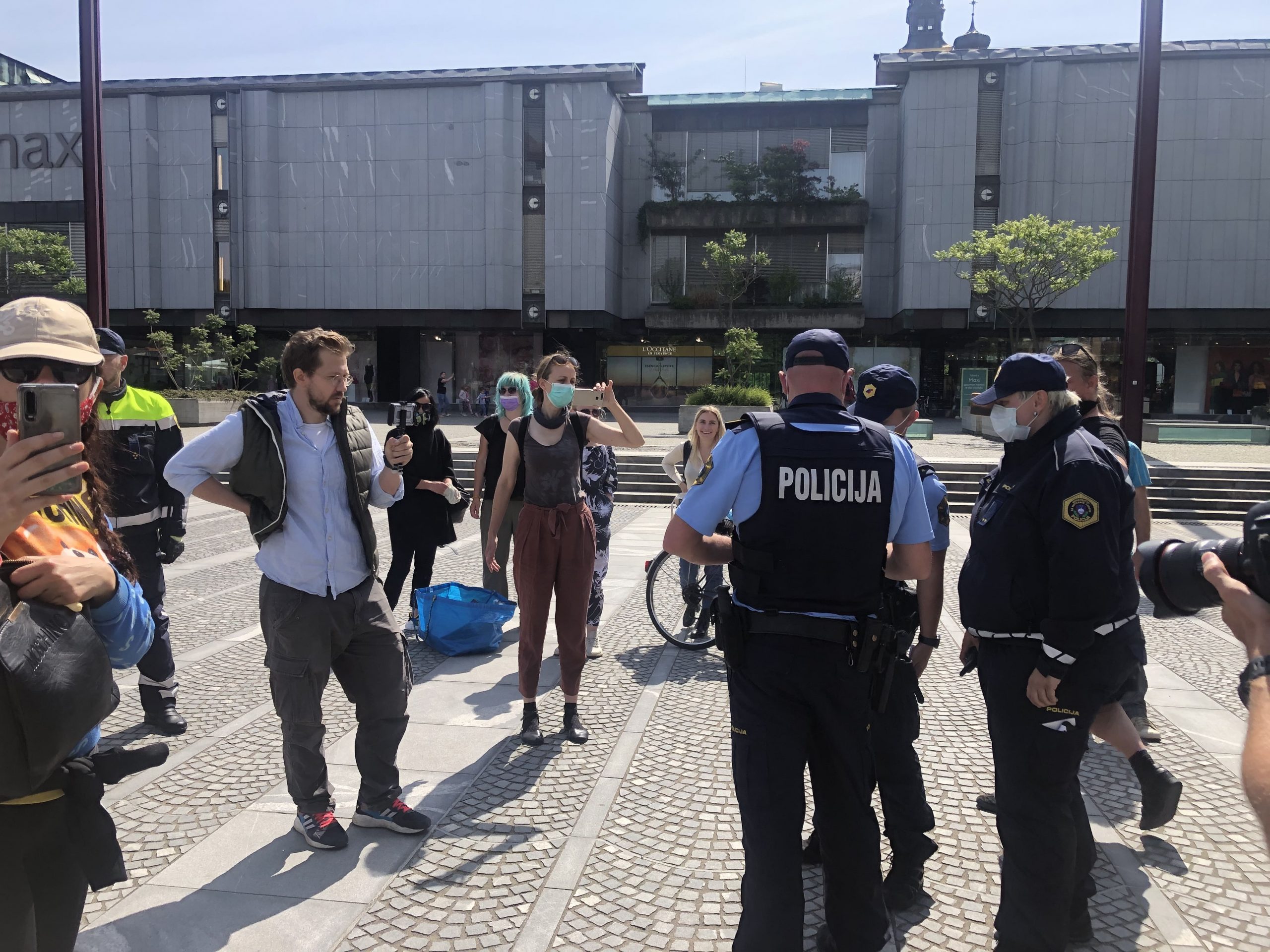 (VIDEO) Incident pred nadaljevanjem protestov: Preden je policija ogradila del Trga Republike, je skupina protestnikov popisala trg z napisom “Naša last”