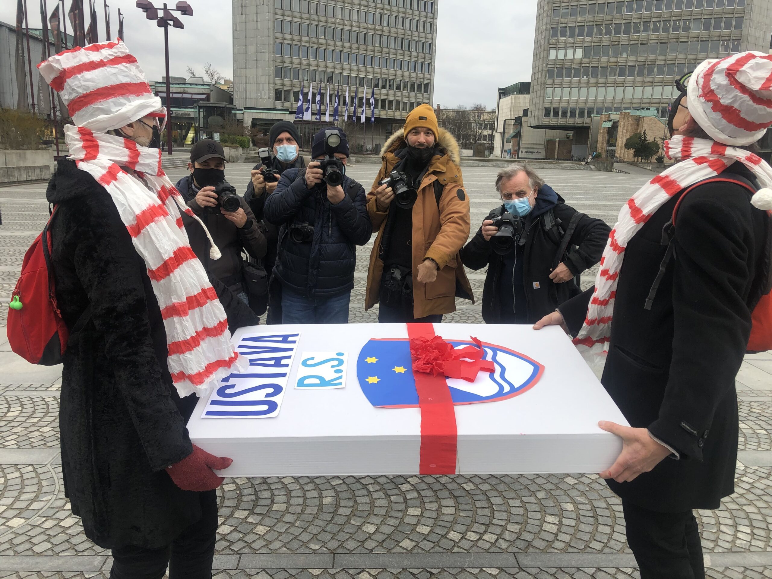 (V ŽIVO) Protestniki tokrat pred vrata stranke SMC – Sedež stranke SMC “predčasno obiskala specialna Božičkova dostavna ekipa in poslancem SMC prinesla poseben XXL izvod Ustave Republike Slovenije”